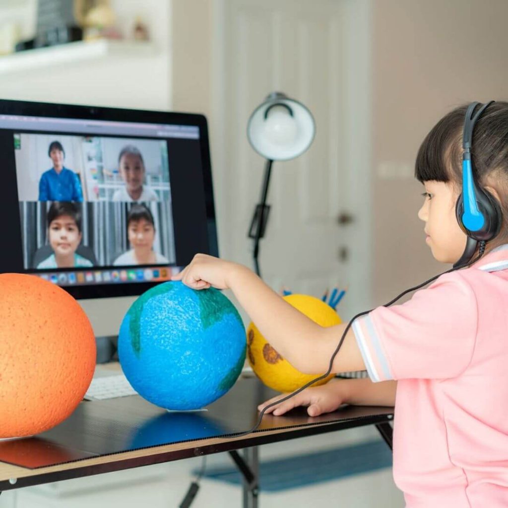 Elementary student video conferencing her teacher and classmates